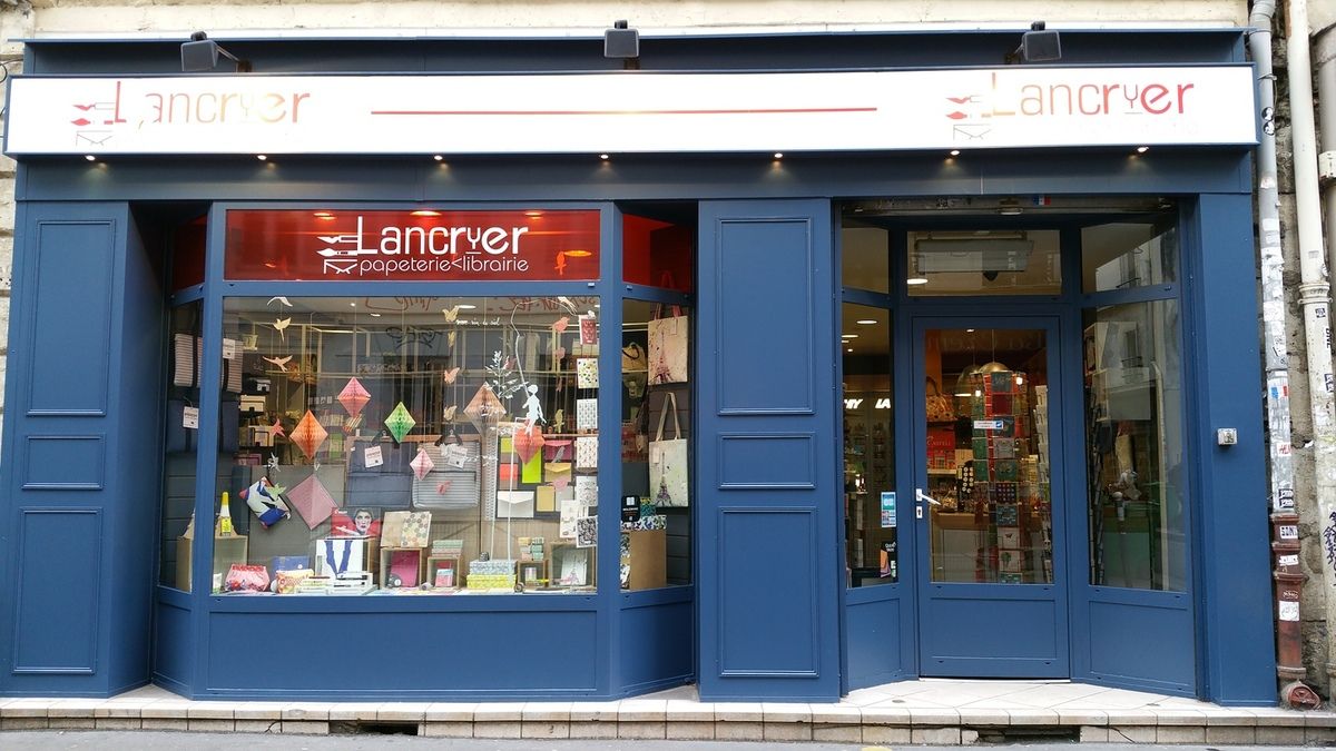 La devanture bleue de la papeterie Lancryer, avec son enseigne rouge et sa vitrine, rue de Lancry