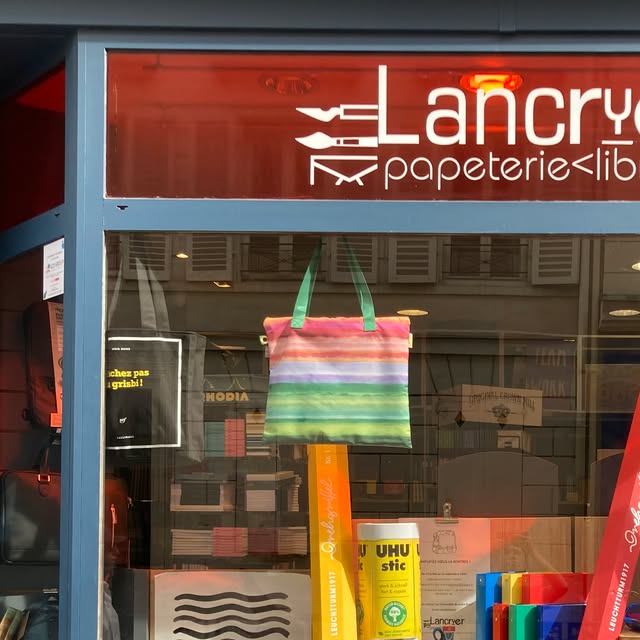 L'enseigne Lancryer papeterie librairie en lettres blanches sur verre rouge, au-dessus de la vitrine