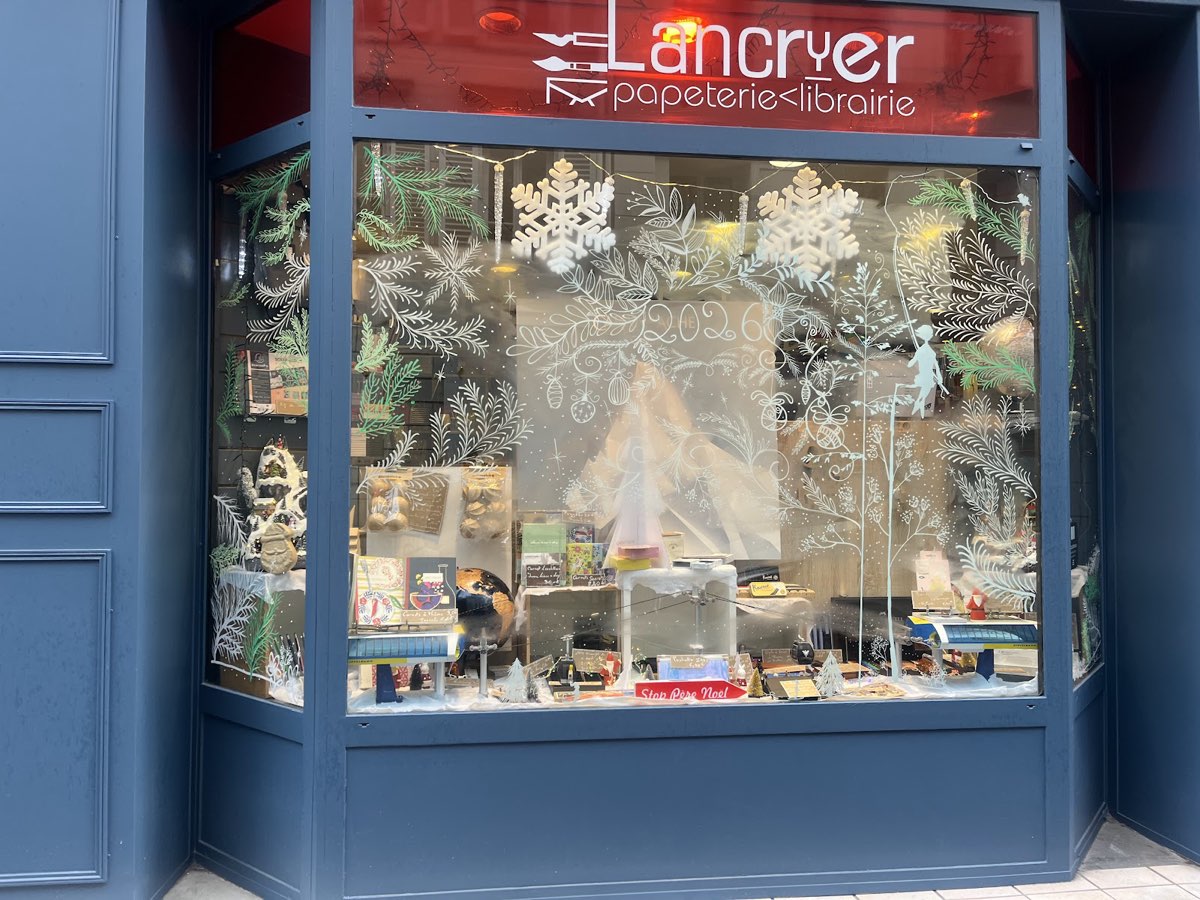 La vitrine de Lancryer décorée pour l'hiver, sous l'enseigne rouge papeterie librairie